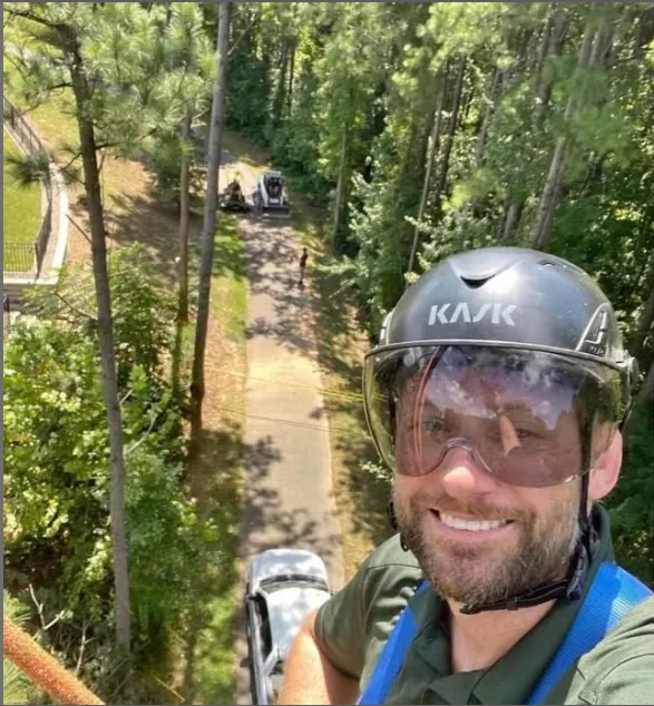 Taylor wearing protective arborist equipment while working in a tree